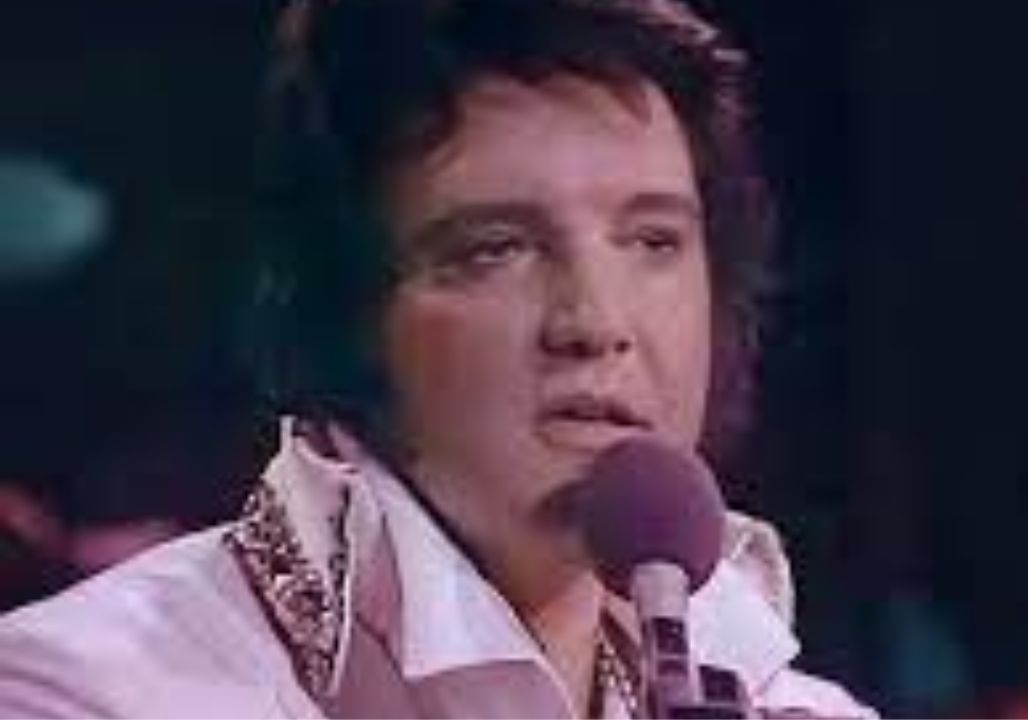 Elvis Presley—his body heavier, his face worn with fatigue—commanded silence the moment he began singing “Hurt.” This was not the young, electrifying Elvis of the past, but a man fighting the weight of his own decline. Yet when the melody swelled, he gave everything he had, stretching the high note until the hall itself seemed to tremble, before the crowd erupted in thunderous applause. With a weary smile and a hint of humor, Elvis said, “Thank you… I can’t do it any better,” only to surprise everyone by launching into the climax once more. In that instant, it was more than music—it was his soul pouring out. Tired but unyielding, he sang as if it were his last breath, a final testament that his life was bound to song. For many, it became one of Elvis’s most hauntingly unforgettable moments. Elvis Presley—his body heavier, his face worn with fatigue—commanded silence the moment he began singing “Hurt.” This was not the young, electrifying Elvis of the past, but a man fighting the weight of his own decline. Yet when the melody swelled, he gave everything he had, stretching the high note until the hall itself seemed to tremble, before the crowd erupted in thunderous applause. With a weary smile and a hint of humor, Elvis said, “Thank you… I can’t do it any better,” only to surprise everyone by launching into the climax once more. In that instant, it was more than music—it was his soul pouring out. Tired but unyielding, he sang as if it were his last breath, a final testament that his life was bound to song. For many, it became one of Elvis’s most hauntingly unforgettable moments.