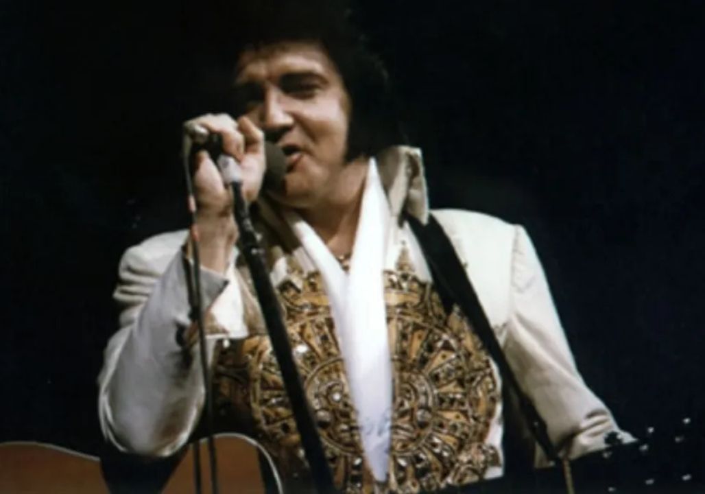 Elvis Presley’s last performance was strange, almost as if he knew it would be the final time. On the evening of June 26, 1977, at Market Square Arena in Indianapolis, he walked onto the stage for what would become his last goodbye to the world. The lights blazed and the crowd erupted, but behind the curtain stood a man fighting through pain and exhaustion, holding on to the one thing that still gave him purpose: the music. No one can say for certain if Elvis truly knew, yet those who were there spoke of a quiet, almost sacred feeling that he did. Elvis Presley’s last performance was strange, almost as if he knew it would be the final time. On the evening of June 26, 1977, at Market Square Arena in Indianapolis, he walked onto the stage for what would become his last goodbye to the world. The lights blazed and the crowd erupted, but behind the curtain stood a man fighting through pain and exhaustion, holding on to the one thing that still gave him purpose: the music. No one can say for certain if Elvis truly knew, yet those who were there spoke of a quiet, almost sacred feeling that he did.